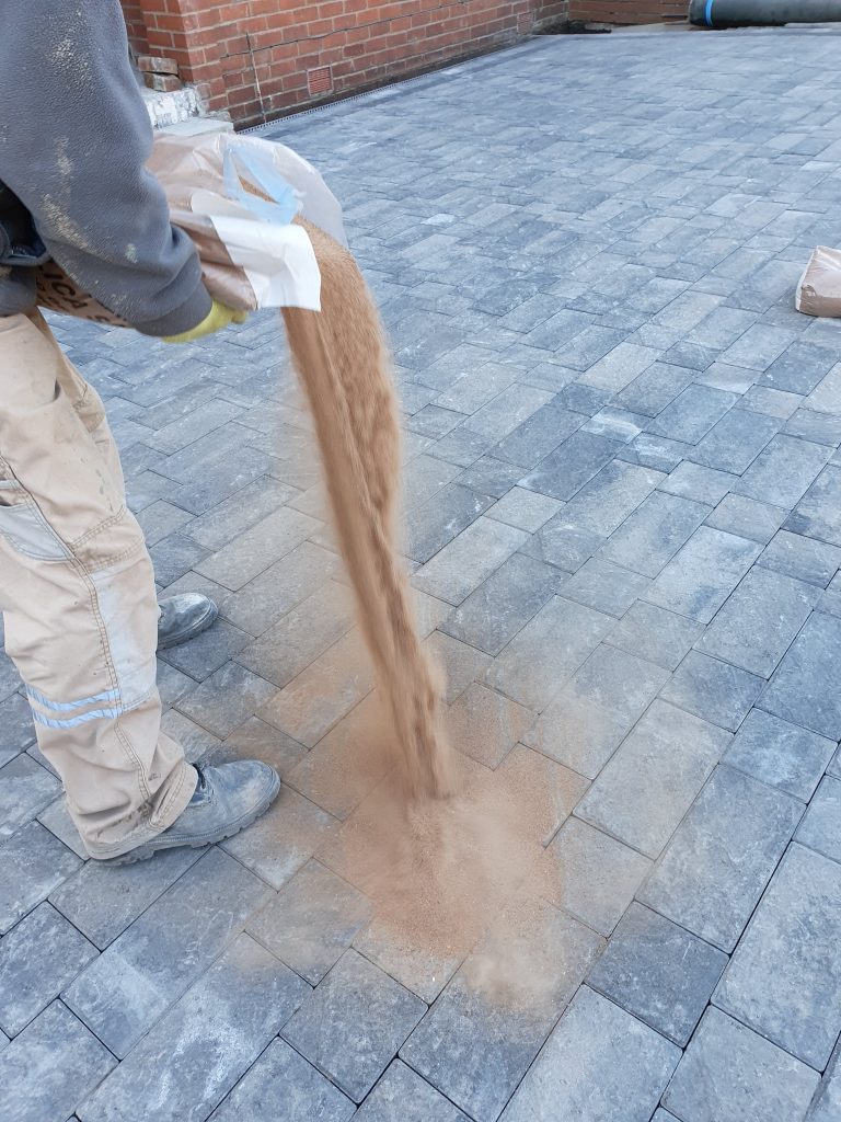 Silica sand poured on block paving to lock the blocks
