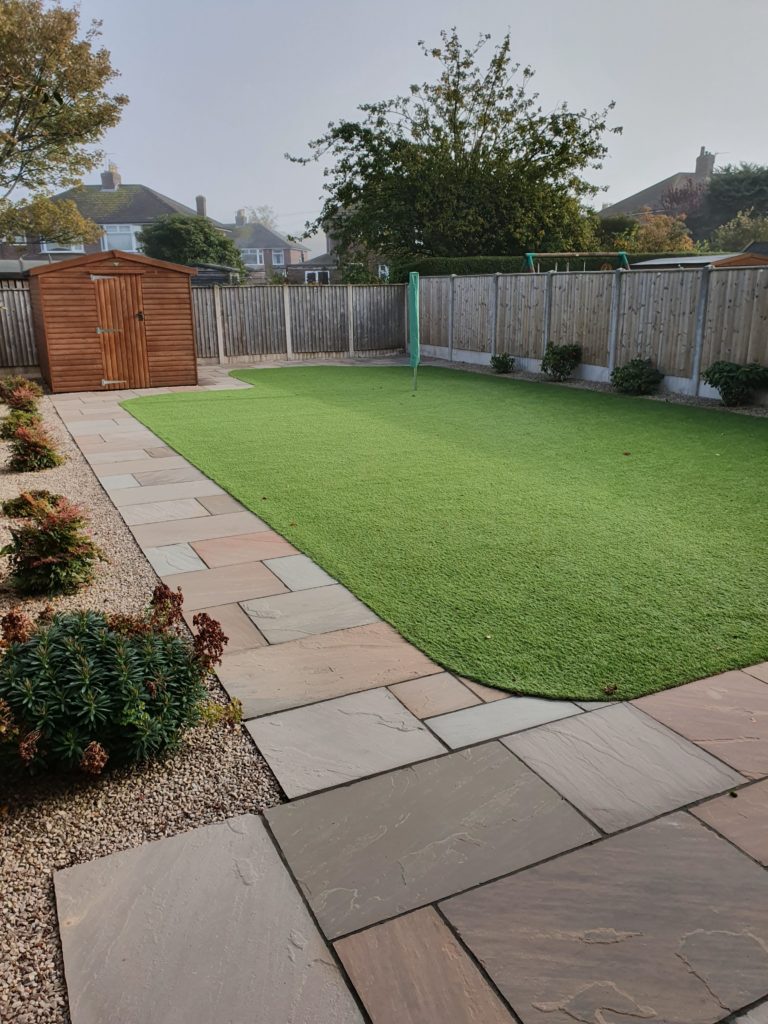 large artificial grass lawn with indian sandstone perimeter by landform landscaping Carlisle Cumbria